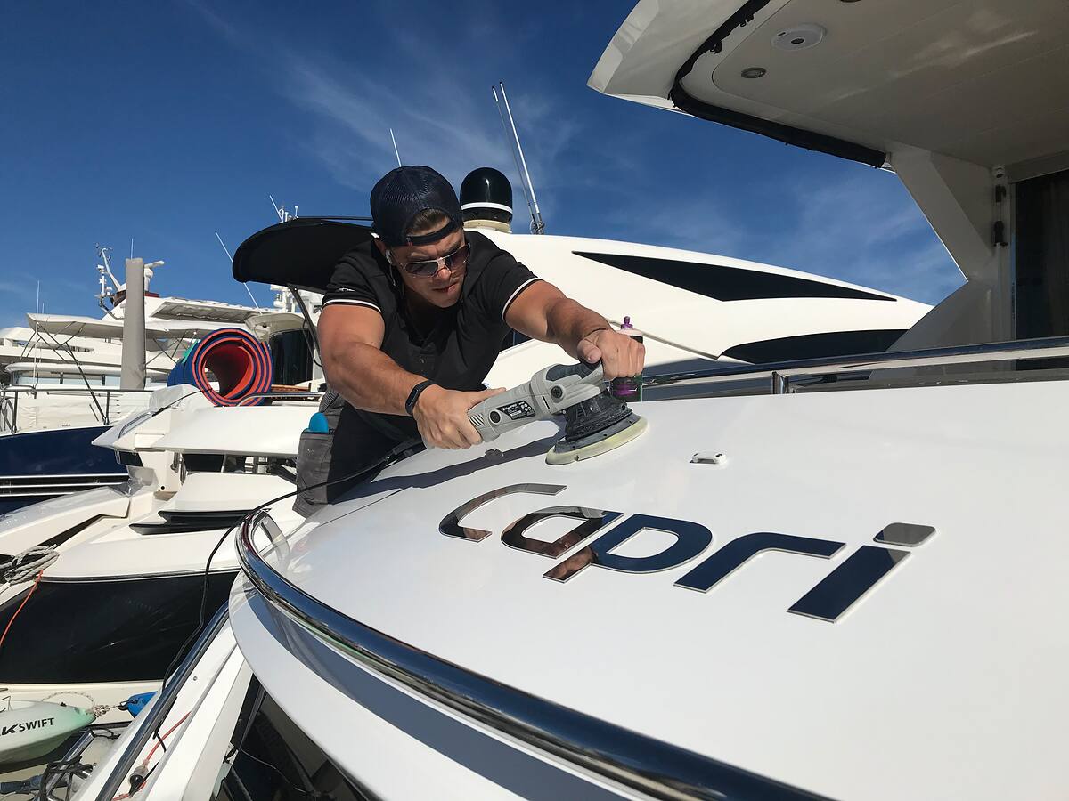 Shiny Detailing machine polishing the foredeck of a motor yacht at a Sydney marina